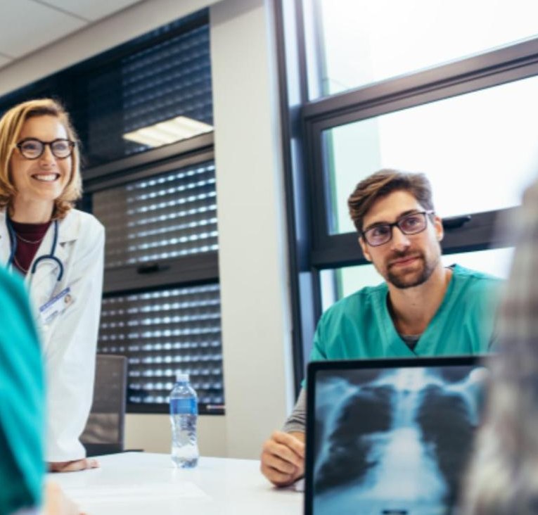 Physicians and clinicians meeting around a table