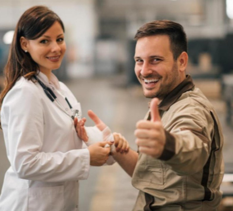 A physician wraps a smiling worker's injured hand