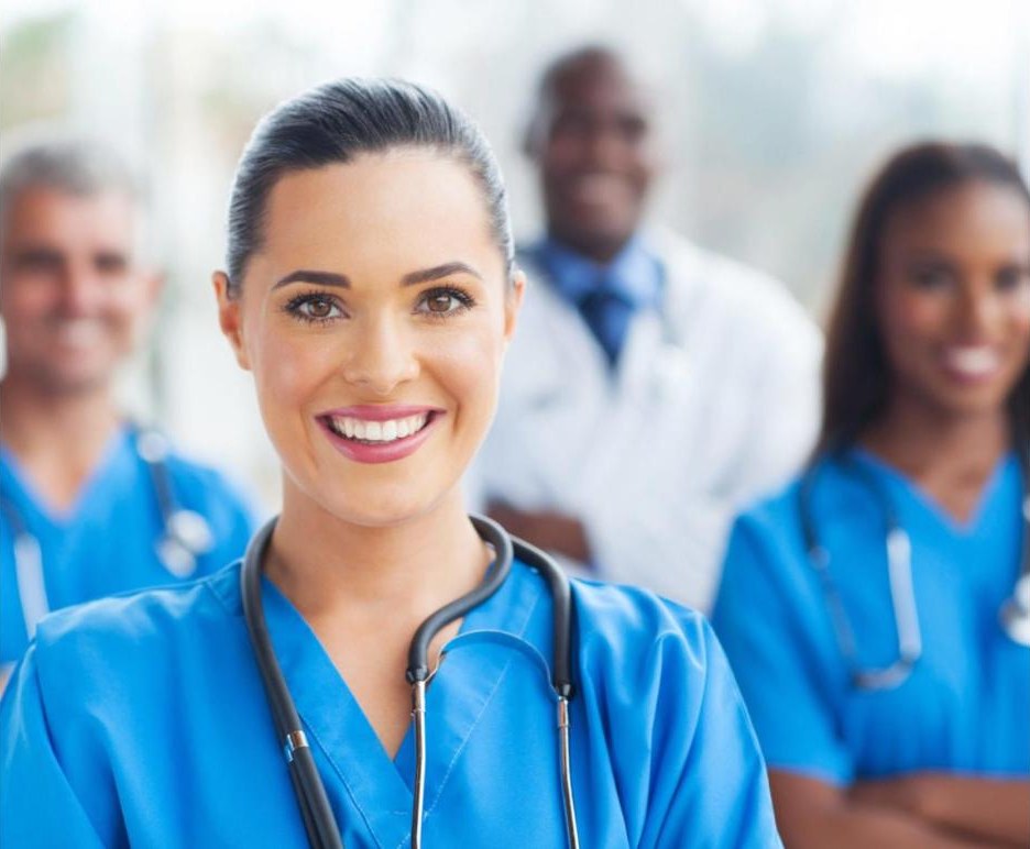 Smiling physicians and nurses in scrubs and white coats